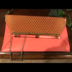 Bebe leather clutch purse with gold strap.